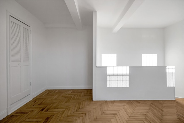 spare room featuring beamed ceiling, plenty of natural light, dark parquet flooring, and radiator