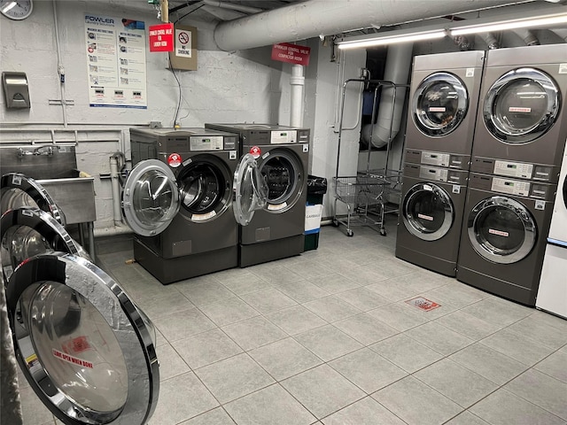 laundry room featuring washing machine and dryer, stacked washer / drying machine, and light tile patterned flooring