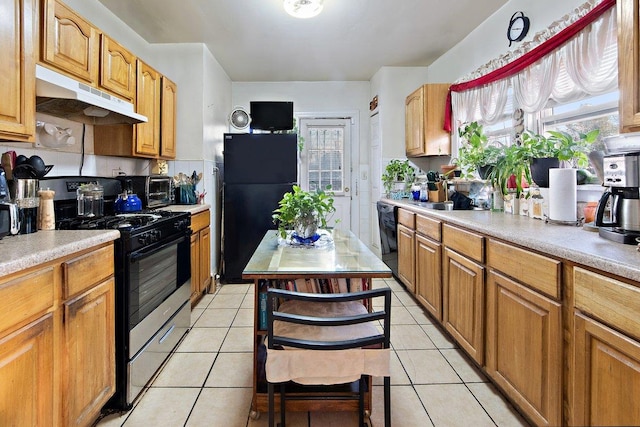 kitchen with light tile patterned floors, sink, and black appliances