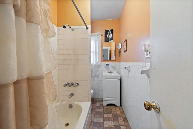 full bathroom with toilet, tile walls, tiled shower / bath, and sink