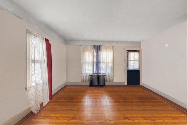 spare room with hardwood / wood-style flooring and radiator heating unit