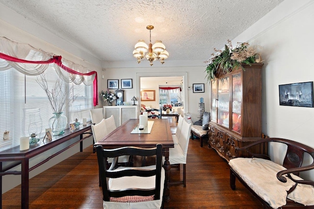 dining area with a chandelier, dark hardwood / wood-style flooring, and a textured ceiling