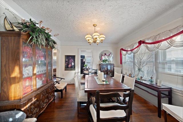 dining space featuring a textured ceiling, dark hardwood / wood-style flooring, and a chandelier