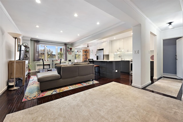 living room featuring ceiling fan, crown molding, and dark wood-type flooring