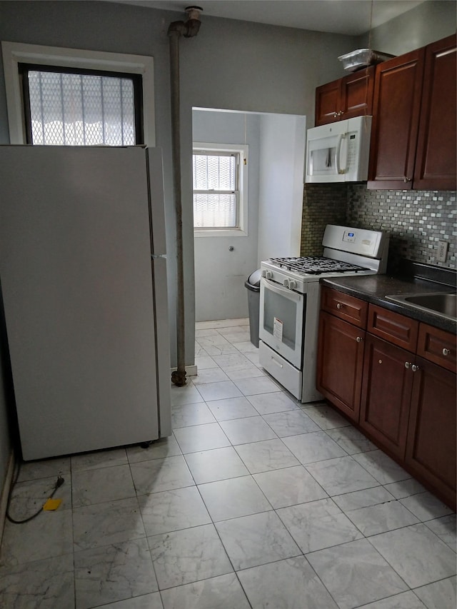 kitchen with sink, white appliances, and backsplash