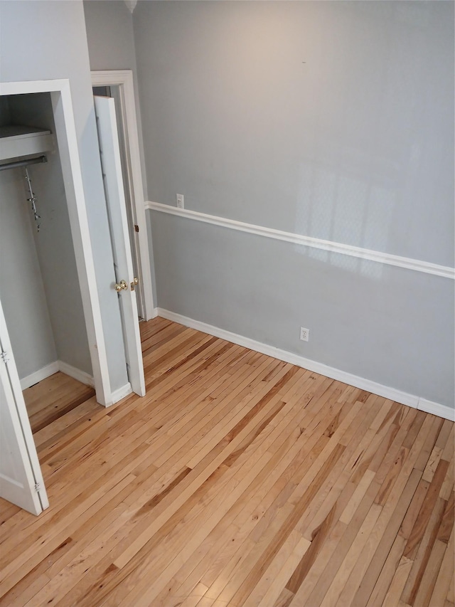 unfurnished bedroom featuring light hardwood / wood-style flooring and a closet