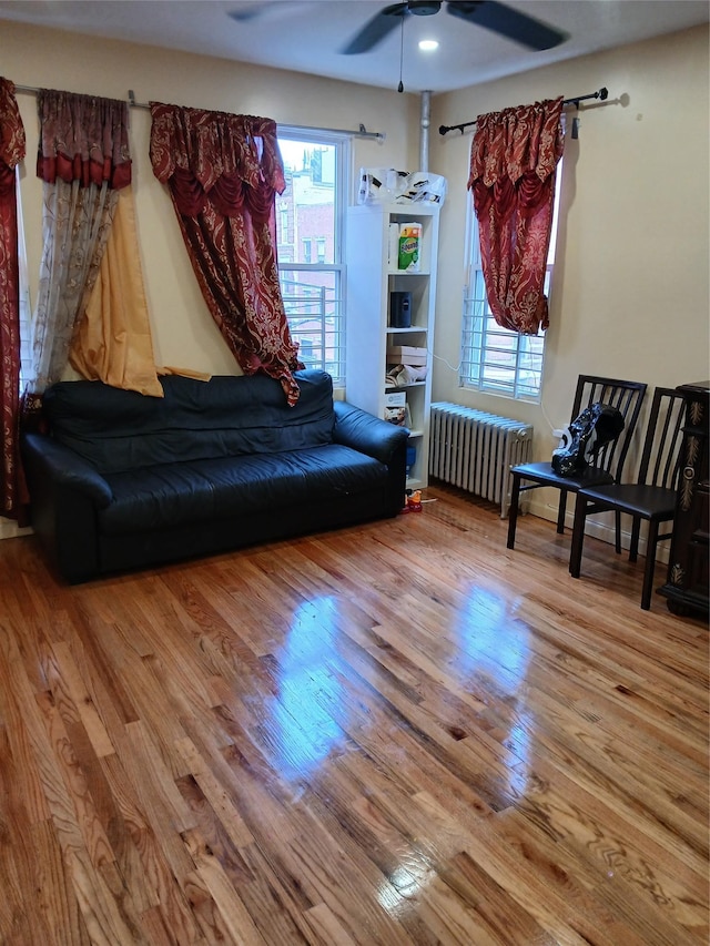 sitting room with ceiling fan, wood-type flooring, and radiator