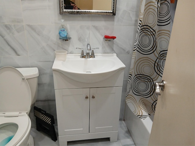 bathroom featuring vanity, toilet, decorative backsplash, and tile walls