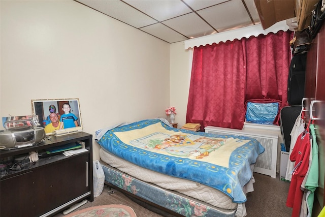 carpeted bedroom with a paneled ceiling