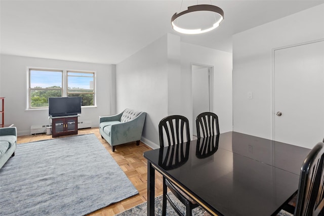 dining space with baseboard heating and parquet floors