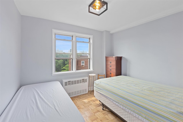 bedroom with light parquet flooring and radiator