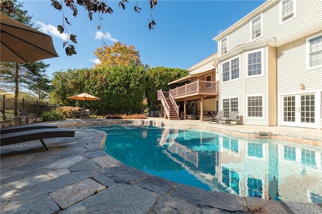 view of swimming pool featuring french doors, a patio, and a wooden deck