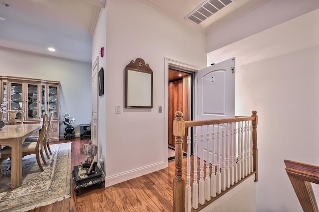 corridor with wood-type flooring and crown molding