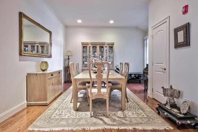 dining space with light wood-type flooring and crown molding