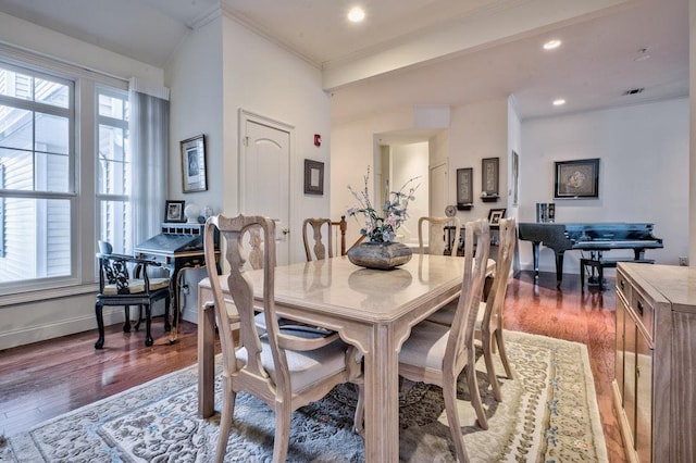 dining area with a healthy amount of sunlight, ornamental molding, and dark wood-type flooring