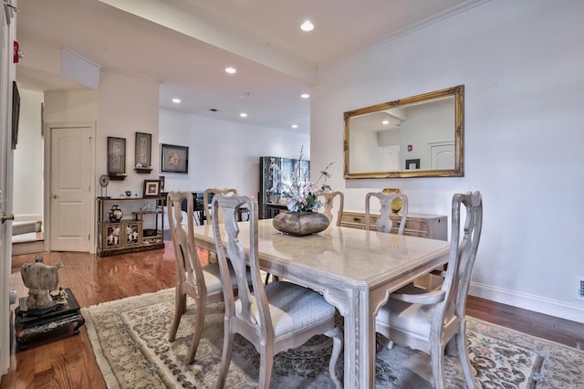 dining space with wood-type flooring and ornamental molding