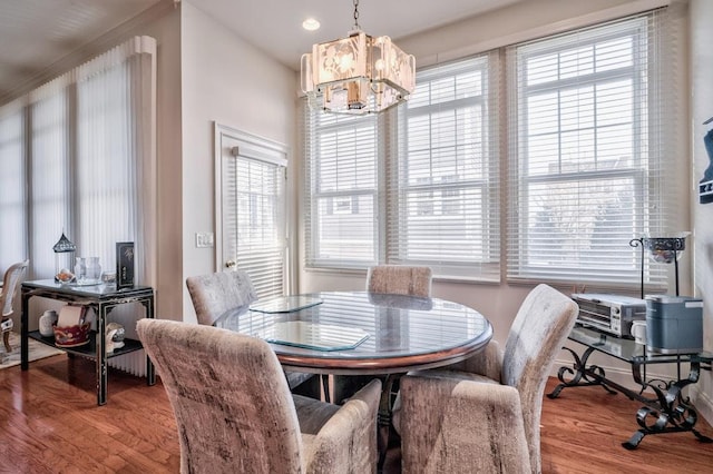 dining space with a notable chandelier, light wood-type flooring, and crown molding