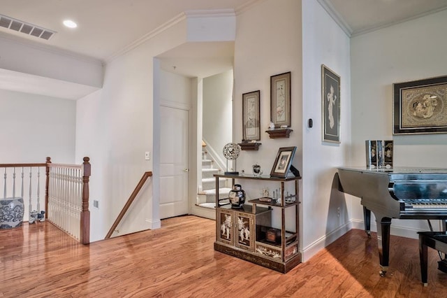 hallway featuring light wood-type flooring and crown molding