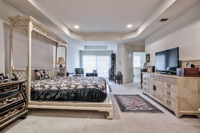 carpeted bedroom with a tray ceiling