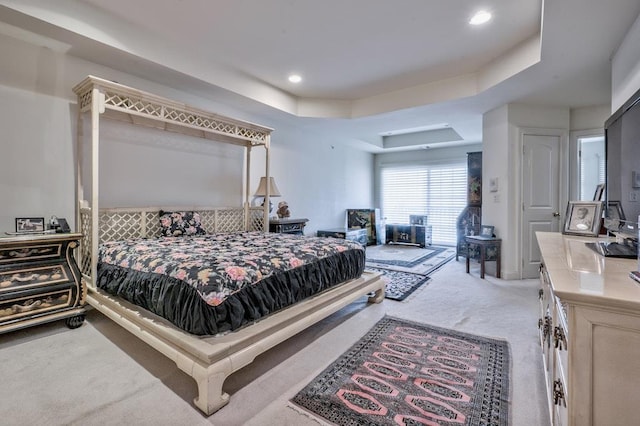 carpeted bedroom with a raised ceiling