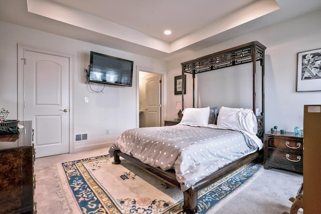 carpeted bedroom featuring a raised ceiling