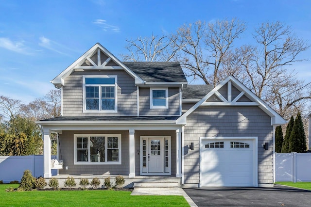 craftsman-style home featuring covered porch, a garage, and a front lawn