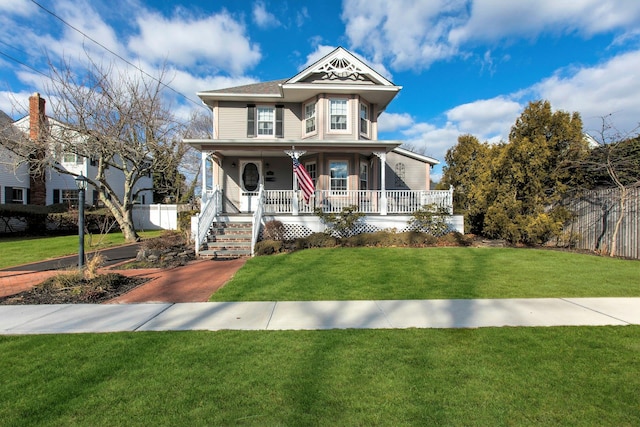 victorian house featuring covered porch and a front lawn