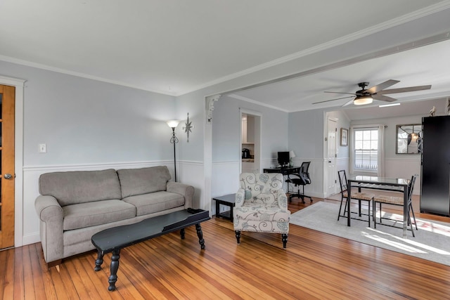 living room featuring ceiling fan, light hardwood / wood-style floors, and crown molding