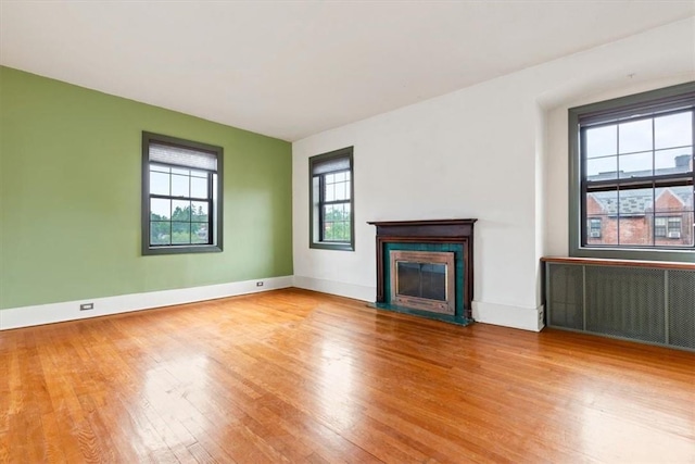 unfurnished living room with radiator heating unit and hardwood / wood-style flooring