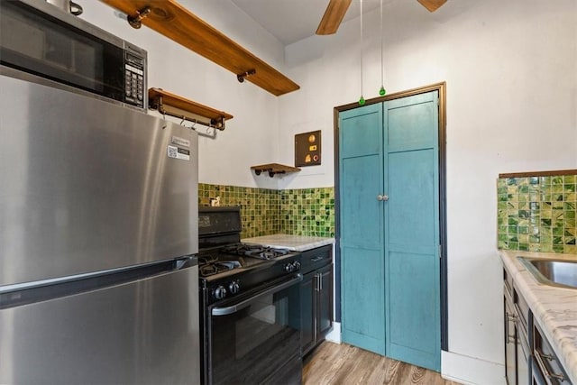 kitchen with backsplash, stainless steel appliances, and light hardwood / wood-style floors