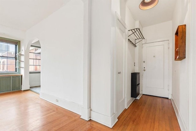 hallway featuring radiator heating unit and hardwood / wood-style floors