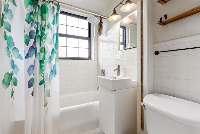 full bathroom featuring sink, toilet, tile walls, and shower / tub combo with curtain