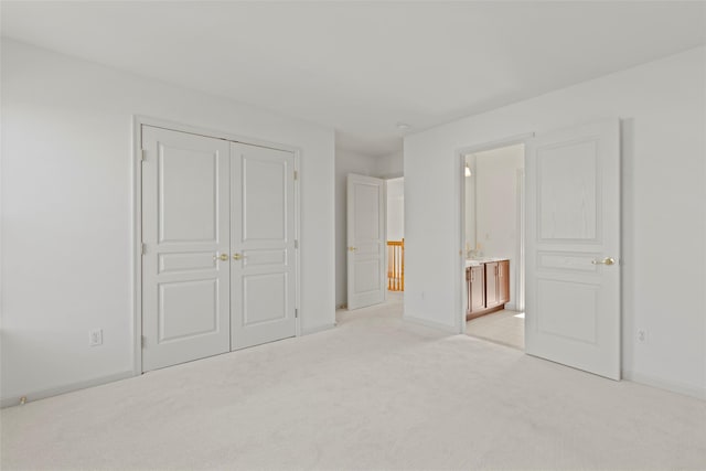 unfurnished bedroom with light carpet, connected bathroom, and a closet