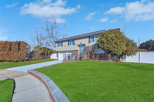 bi-level home featuring a garage and a front lawn