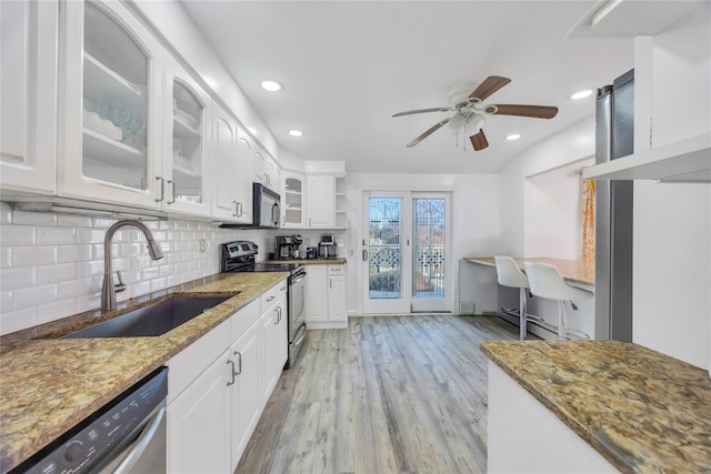 kitchen with dark stone countertops, white cabinetry, sink, and appliances with stainless steel finishes