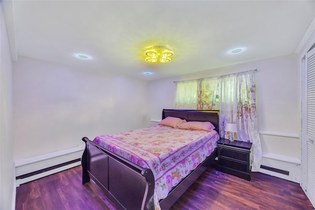 bedroom featuring a closet, dark wood-type flooring, and a baseboard radiator