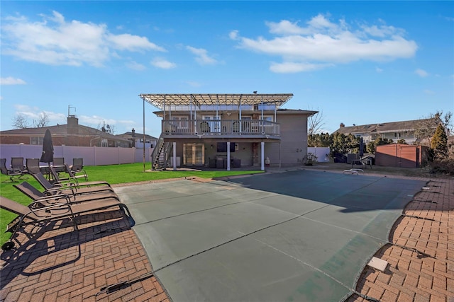 rear view of house with a pergola, a deck, a patio area, and a lawn