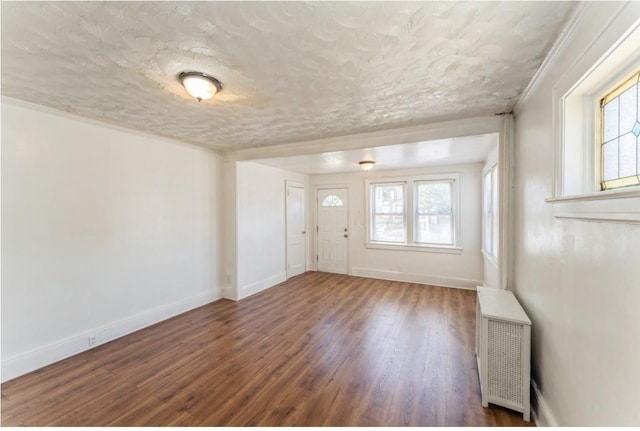 entrance foyer with a textured ceiling, dark hardwood / wood-style flooring, and radiator