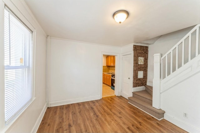 empty room featuring ornamental molding and hardwood / wood-style flooring