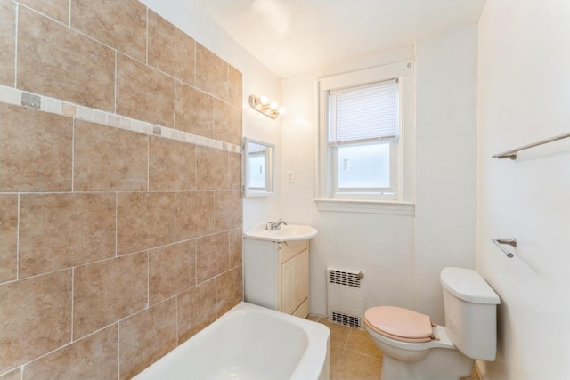 bathroom featuring tile patterned flooring, a bathing tub, toilet, radiator heating unit, and vanity