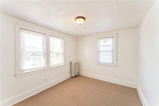 carpeted spare room featuring radiator