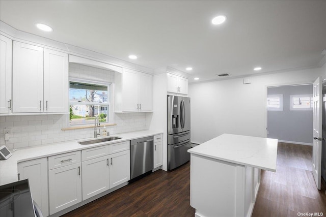 kitchen with sink, dark hardwood / wood-style floors, appliances with stainless steel finishes, a kitchen island, and white cabinetry