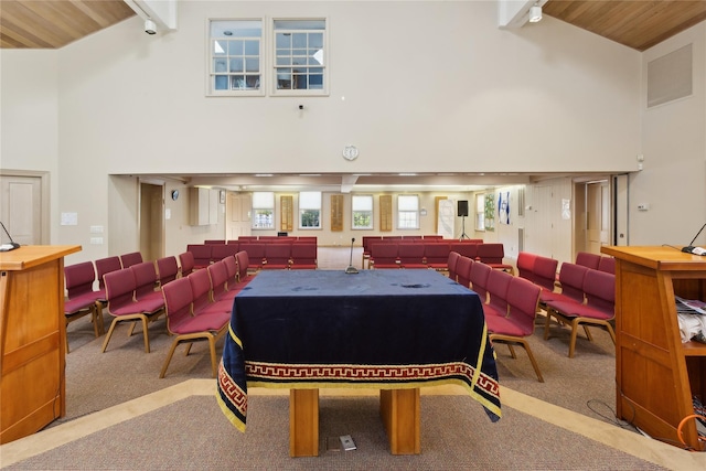 rec room with light colored carpet, beam ceiling, and high vaulted ceiling