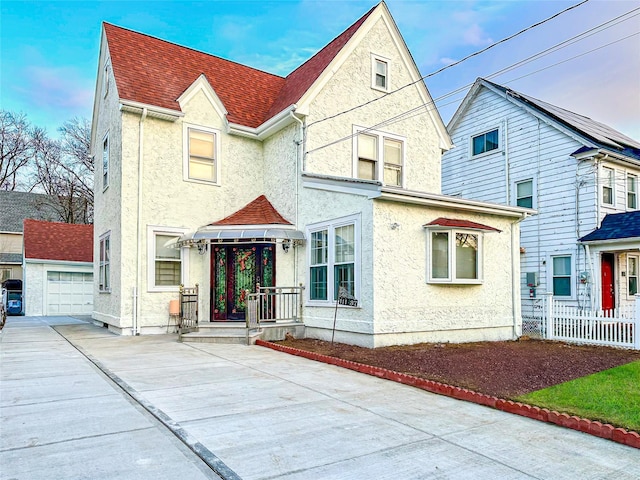 view of front of house featuring a garage and an outbuilding