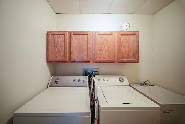 laundry room with washing machine and clothes dryer and cabinets