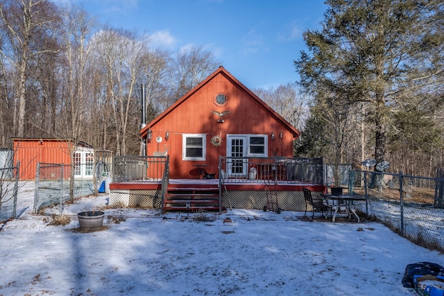 snow covered house featuring a wooden deck