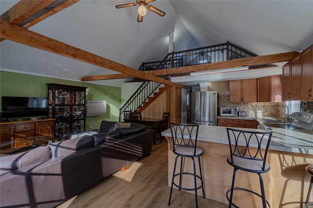 living room featuring high vaulted ceiling, sink, light hardwood / wood-style flooring, ceiling fan, and beamed ceiling