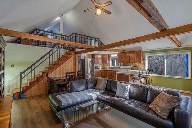 living room with ceiling fan, beam ceiling, dark hardwood / wood-style flooring, and high vaulted ceiling