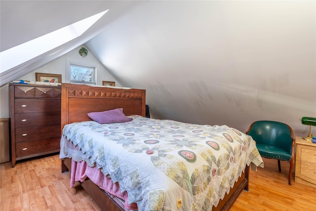 bedroom with light hardwood / wood-style floors and lofted ceiling with skylight