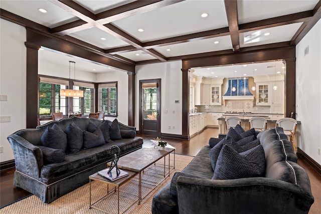 living room with ornate columns, coffered ceiling, beamed ceiling, plenty of natural light, and hardwood / wood-style floors